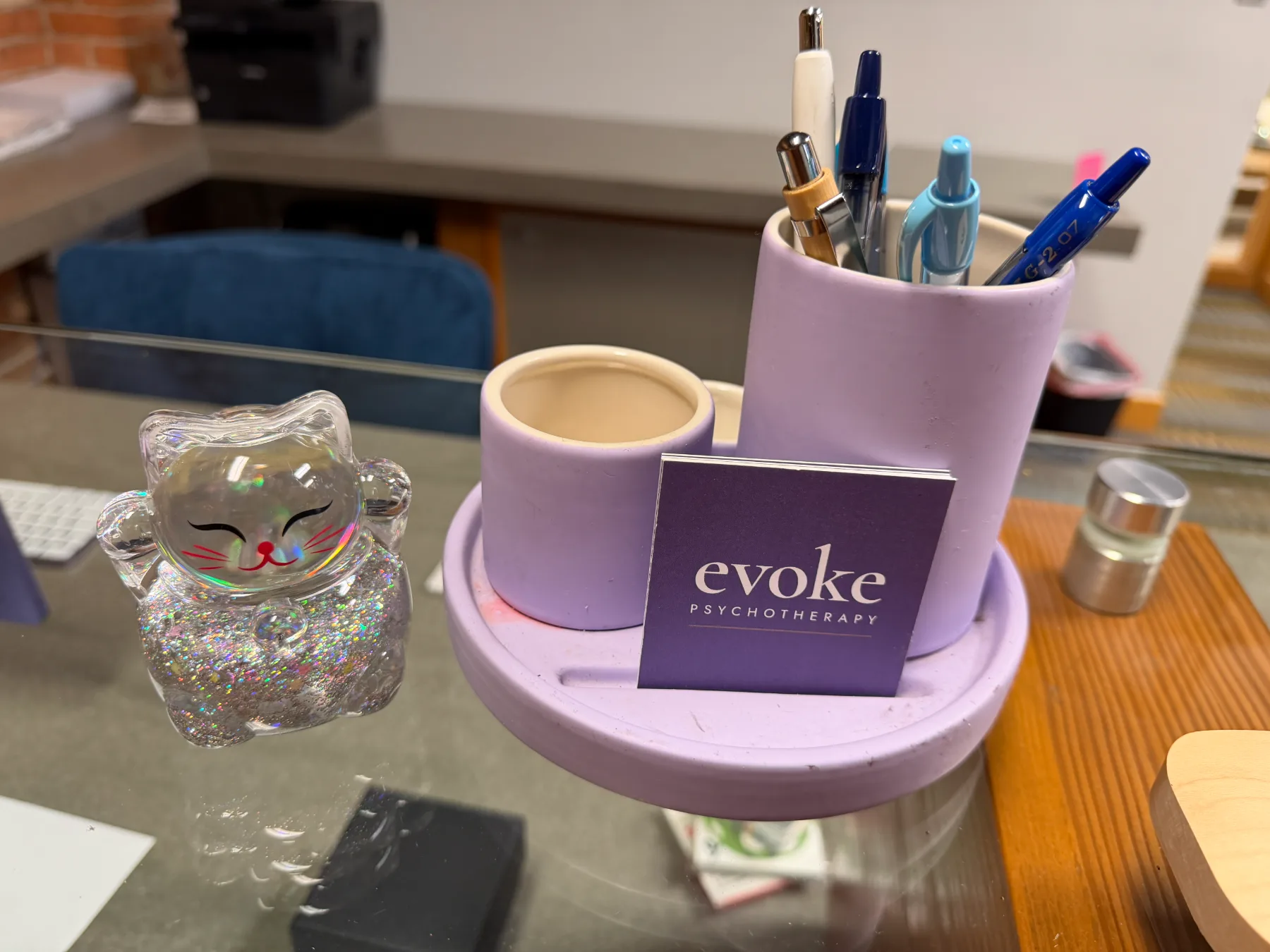 A lavender desk set with pens and an evoke psychotherapy card at the practice front desk